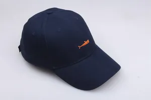 Detail of a dark blue baseball cap featuring vibrant orange whale embroidery on cotton twill