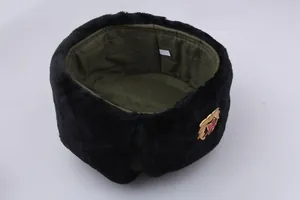 Detail of black faux fur Ushanka with green quilted lining and Soviet star badge