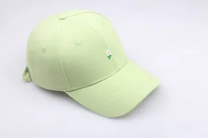 Détail de la broderie de marguerite sur une casquette de baseball vert menthe