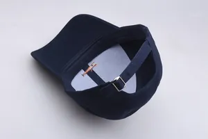 Detailed top view of navy blue cotton baseball cap interior with orange fish embroidery