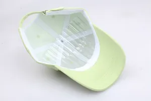 Détail de la casquette en coton vert clair avec doublure intérieure et boucle de réglage en métal