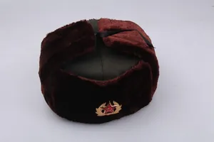 Detail of green ushanka hat with faux fur ear flaps and red star emblem on front