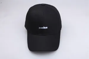 Detailed view of white fish embroidery on a black cotton baseball cap with textured stitching