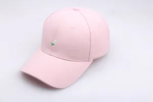 Gros plan d'une casquette rose avec broderie de marguerites blanches sur tissu en coton