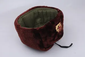 Macro detail of brown faux fur trapper hat with military badge and quilted lining