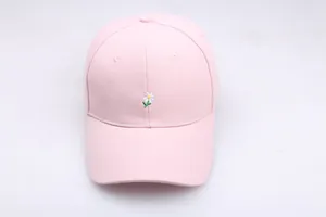 Détail de la broderie marguerite blanche sur le tissu en sergé de coton rose