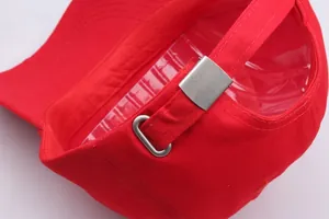 Detailansicht der roten Baumwollkappe mit Vintage-Metallschnalle und Stoffstruktur
