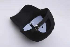 Detail of black cotton baseball cap showing adjustable silver metal buckle and back strap
