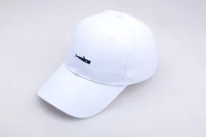 Close-up of precise black fish embroidery on a white cotton baseball cap with ventilation holes