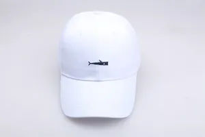 Detailed close-up of blue whale embroidery on white cotton twill baseball cap