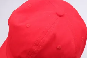 Detail der roten Baumwoll-Baseballkappe mit Fokus auf Nähte und Belüftungslöcher