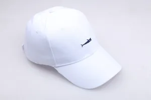 Detailed embroidery of a navy blue fish on a white cotton twill baseball cap