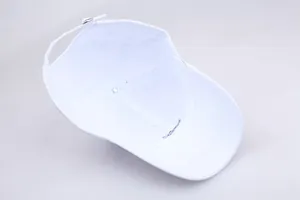 Detail of white baseball cap showing interior stitching and silver metal adjustable buckle