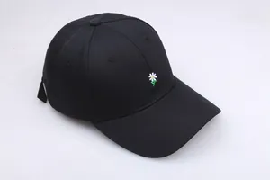 Gros plan sur la broderie marguerite blanche d'une casquette de baseball en coton noir