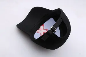 Detail view of adjustable metal buckle and red X embroidery on black punk baseball cap