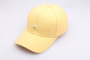 Gros plan d'une casquette de baseball jaune pâle avec broderie marguerite blanche