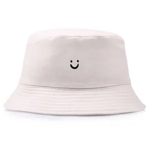 Klassischer beiger Fischerhut aus Baumwolle mit besticktem Smiley-Gesicht auf Weiß