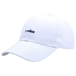 Minimalist white baseball cap with small blue whale embroidery and premium cotton texture