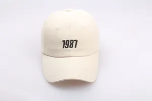 Detailansicht der schwarzen 1987-Stickerei auf einer beigefarbenen Baumwollkappe