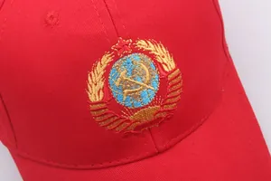 Close-up of intricate Soviet hammer and sickle embroidery on a red cotton baseball cap