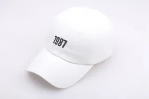 Nahaufnahme der schwarzen 1987 Stickerei auf der Vorderseite der weißen Baseballkappe