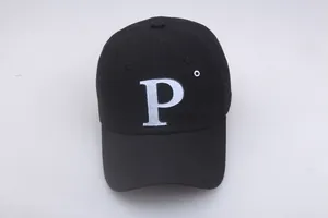 Détail de la broderie P blanche et de la texture en coton sur la casquette de baseball noire
