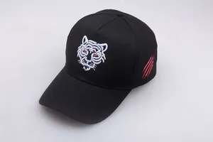 Detailansicht der schwarzen Baseballkappe mit weißer Tiger-Stickerei und roten Krallenspuren