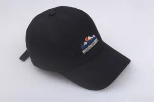 Close-up of colorful mountain embroidery on black cotton baseball cap with text detail