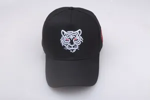 Nahaufnahme der rot-weißen Tigerkopf-Stickerei auf einer schwarzen Baumwoll-Baseballkappe