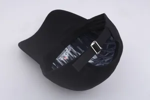 Detail view of black cotton baseball cap showing adjustable silver buckle and metal strap