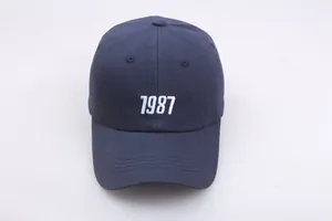 Detail der weißen 1987 Stickerei auf einer marineblauen Baumwoll-Baseballkappe