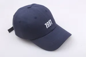 Detailansicht der weißen 1987 Stickerei auf der dunkelblauen Baumwoll-Baseballkappe im Retro