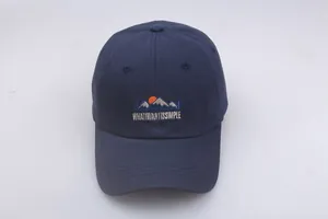 Detailed embroidery on a dark blue cotton baseball cap showing mountain and text detail