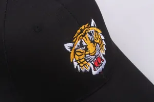 Nahaufnahme der Tiger-Stickerei auf einer schwarzen Baumwoll-Baseballkappe im Streetstyle