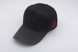 Details der Tigerkopf-Stickerei und des roten Kratzdesigns auf einer schwarzen Kappe