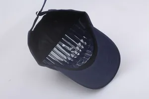Detail of navy baseball cap featuring internal support frame and adjustable metal buckle