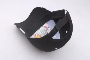 Detail view of black cotton baseball cap showing adjustable velcro strap and embroidery