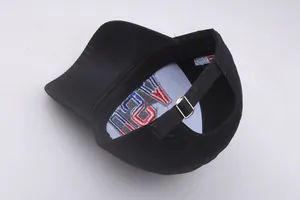 Detailed interior of black cotton baseball cap showing metal buckle and USA flag label