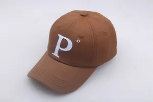 Détail de la casquette de baseball marron avec broderie lettre P et coutures blanches
