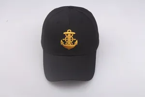 Detailed close-up of a black sailor cap with gold embroidered anchor and rudder nautical emblem