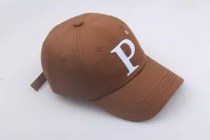 Détail de la lettre P brodée en blanc sur une casquette de baseball marron