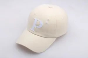 Détail de la casquette beige avec broderie lettre P blanche et texture de coton premium