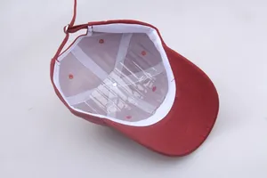 Detail of red cotton baseball cap interior featuring white sweatband and adjustable strap