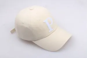 Vue détaillée d'une casquette beige en coton avec broderie lettre P et œillets de ventilation