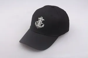 Close-up of anchor and helm embroidery detail on black nautical captain hat