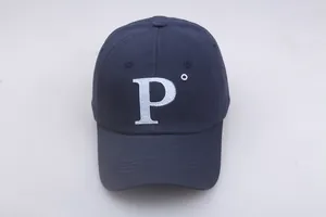 Gros plan sur la broderie blanche de la lettre P sur une casquette en coton bleu foncé