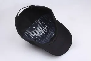 Detail van zwarte katoenen baseballpet met interne ondersteuning en zilveren metalen gesp