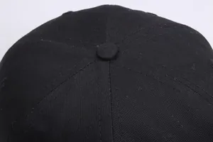 Detailweergave van de bovenkant van een zwarte honkbalpet met knoop en stikselkwaliteit