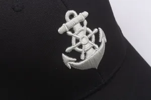 Macro shot of anchor and rudder silver embroidery on black cotton twill sailor cap