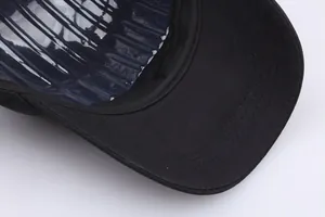 Detail van de stiksels op de klep en het beschermende luchtkussen in de zwarte honkbalpet